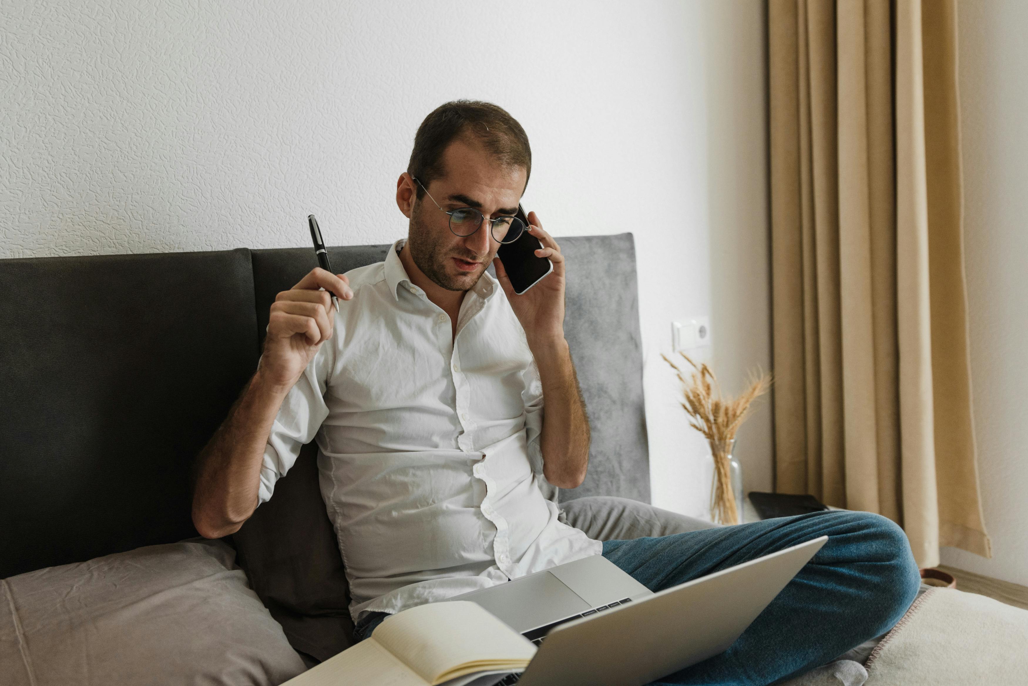 man in white dress shirt sitting on black couch