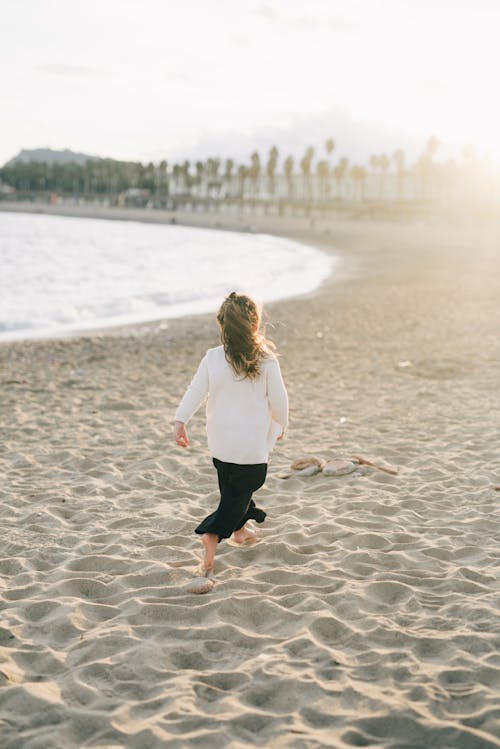 Fille En Chemise à Manches Longues Blanche Et Jupe Noire Marchant Sur La Plage