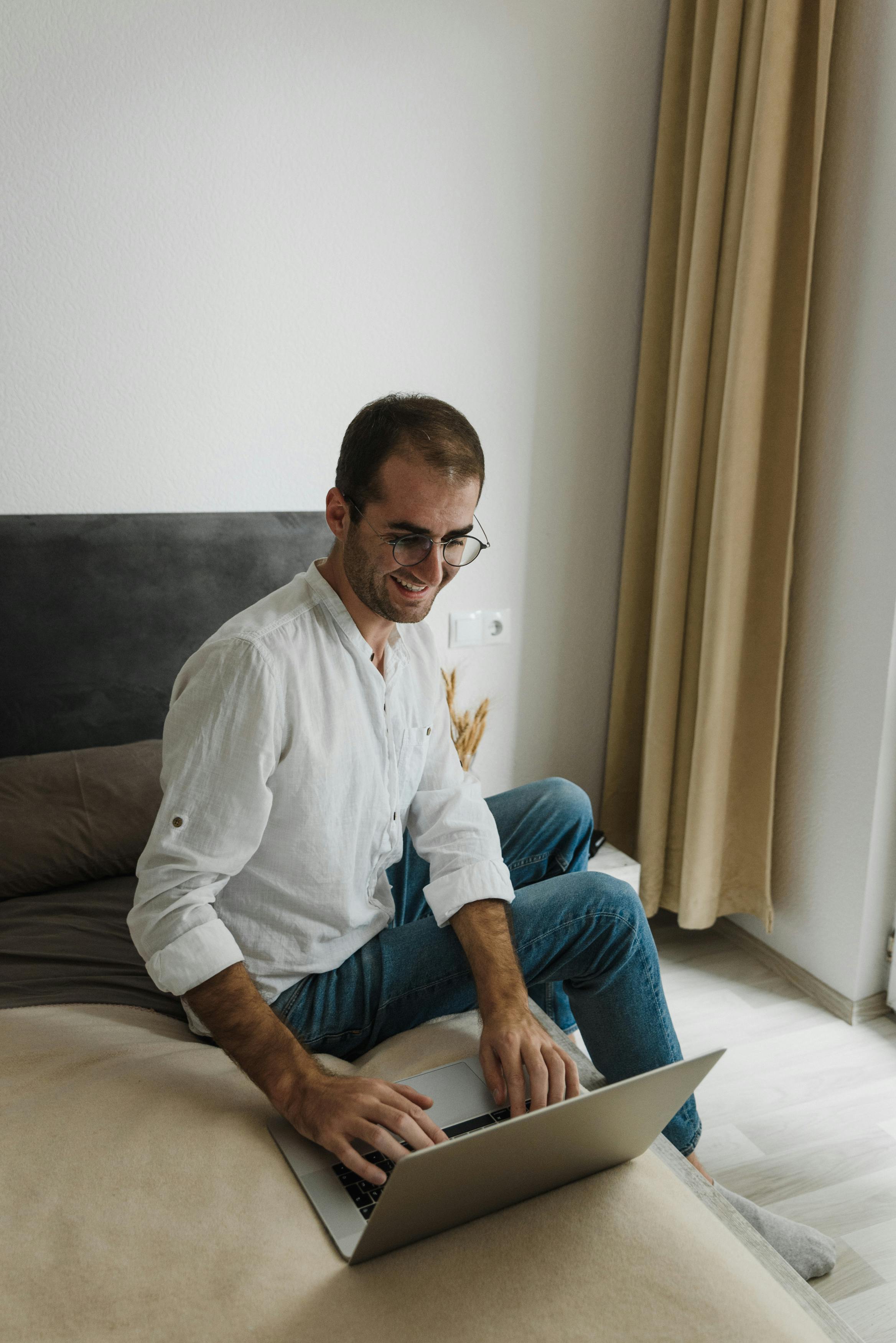 man in white dress shirt sitting on bed