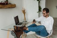 Man in White Dress Shirt and Blue Denim Jeans Sitting on Brown Wooden Chair