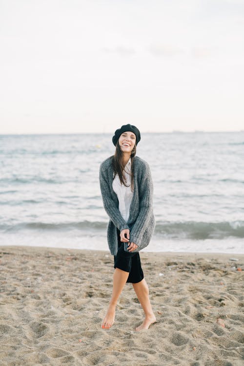 A Woman in Gray Cardigan Standing on Shore