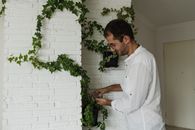 Man in White Dress Shirt Standing Near Green Plant