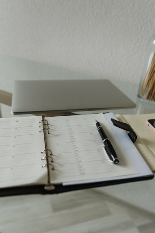 Free Black Click Pen on White Notebook Stock Photo