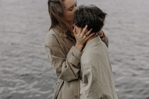 Free A touching embrace between two people in coats by the waterfront. Stock Photo