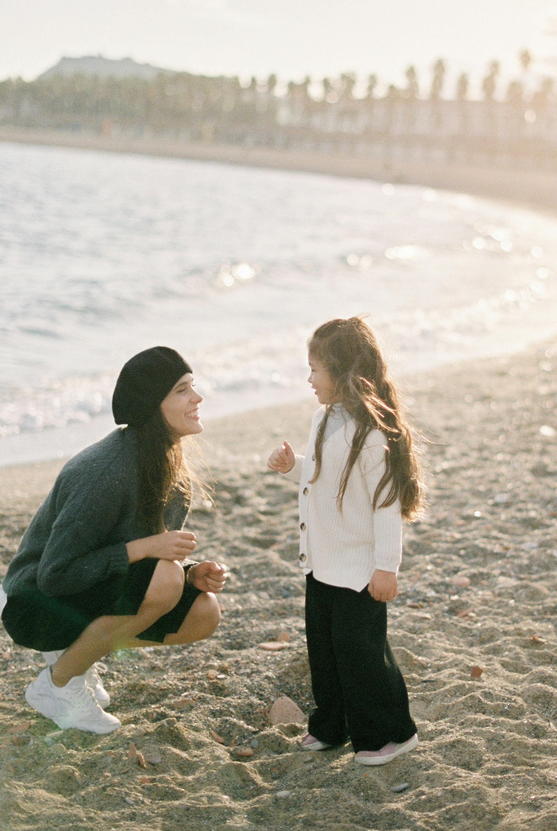 smiling mother and daughter on beach