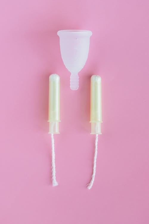 Free Tampons and Menstrual Cup on Pink Surface Stock Photo