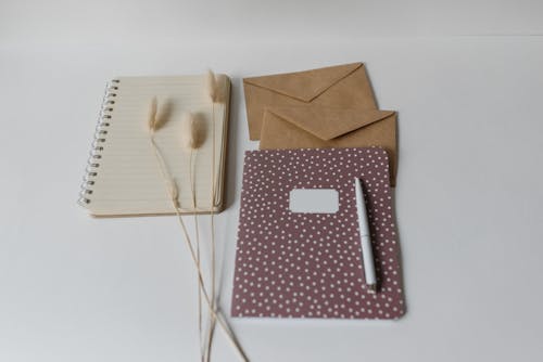 Brown and White Polka Dot Notebook Near the Brown Envelopes 