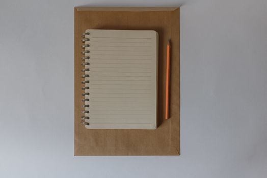 一个内衬笔记本和铅笔的信封，采用自上而下的设计，展现了最低限度的设计感