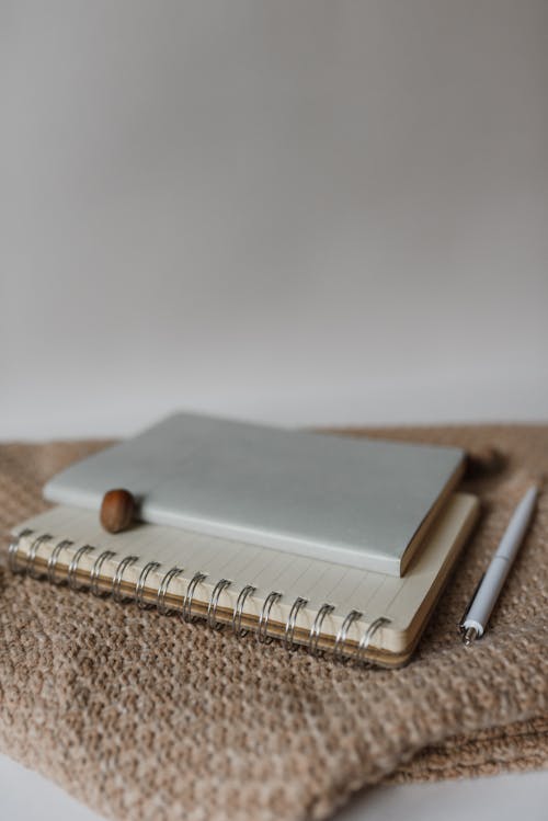 Free A Notebook and Pen on the Sweater Stock Photo