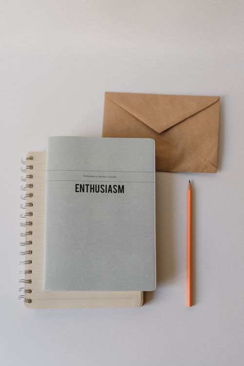 Free Top view of a minimalist setup with a notebook, envelope, and pencil on a table. Stock Photo