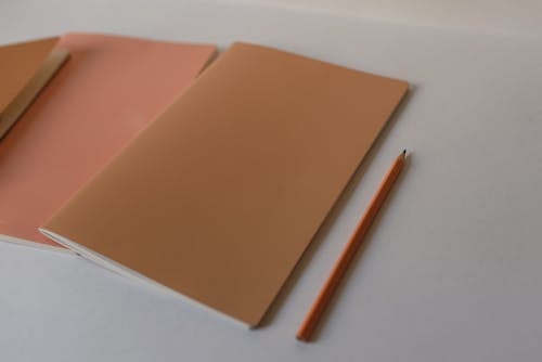 Pencil near Notepads with Blank Covers