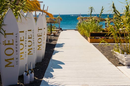 Relaxing beachside resort in Santorini with Moët surfboards and lush surroundings.