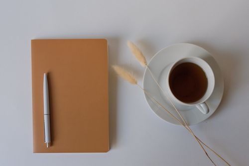 Free Minimalist flat lay composition of coffee, notepad, and pen on a white background. Stock Photo