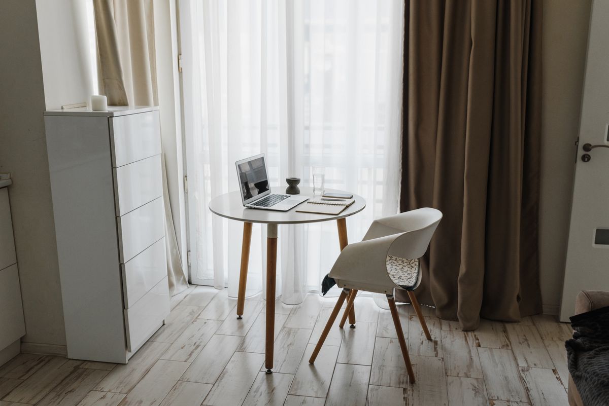 Masa rotunda mica cu laptop intr-un apartament inchiriat