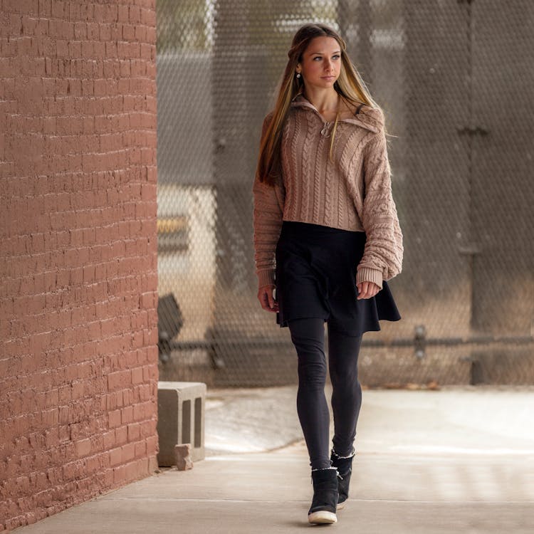 Stylish Woman Walking On Sidewalk Near Building