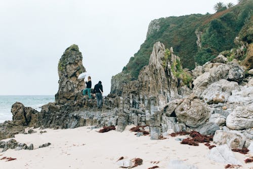 Two People on Boulders on Seaside