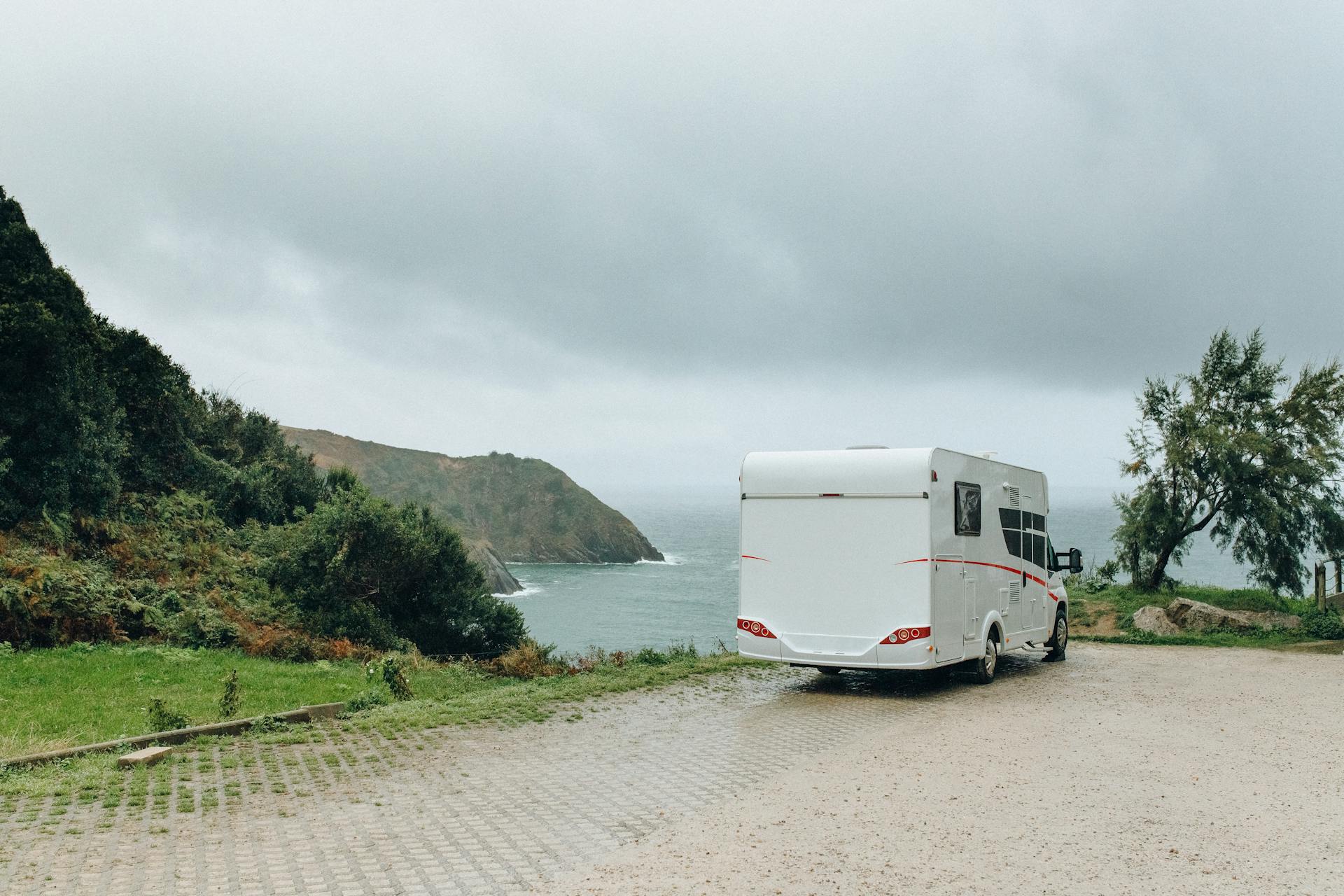 White Trailer on Gray Concrete Road Near Green Grass Field