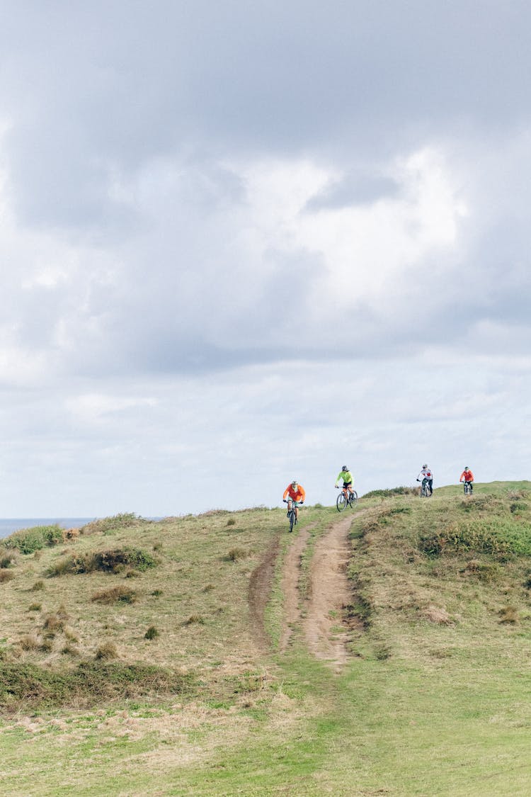 People Biking On A Dirt Road