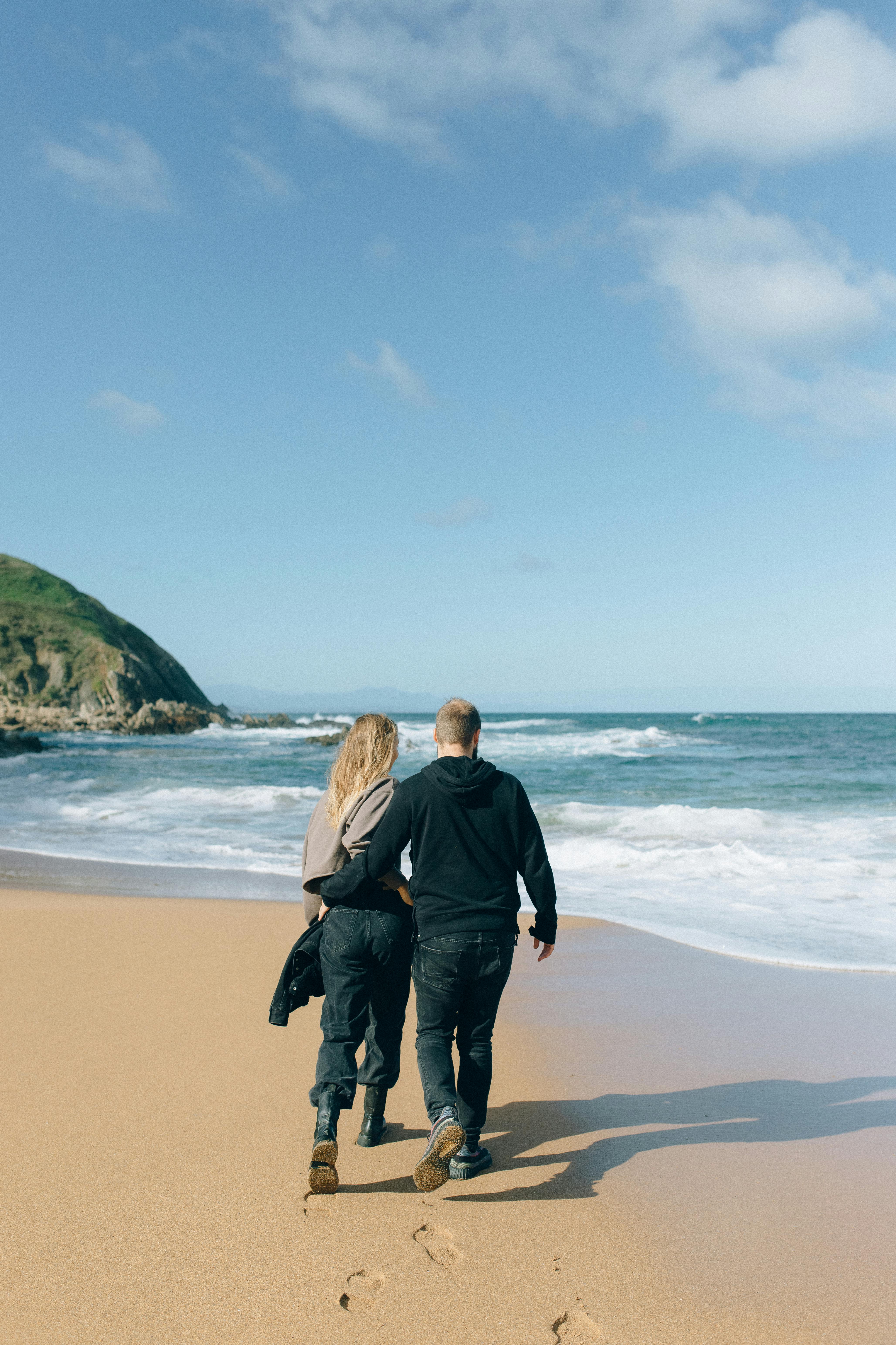 back view of a couple walking on beach