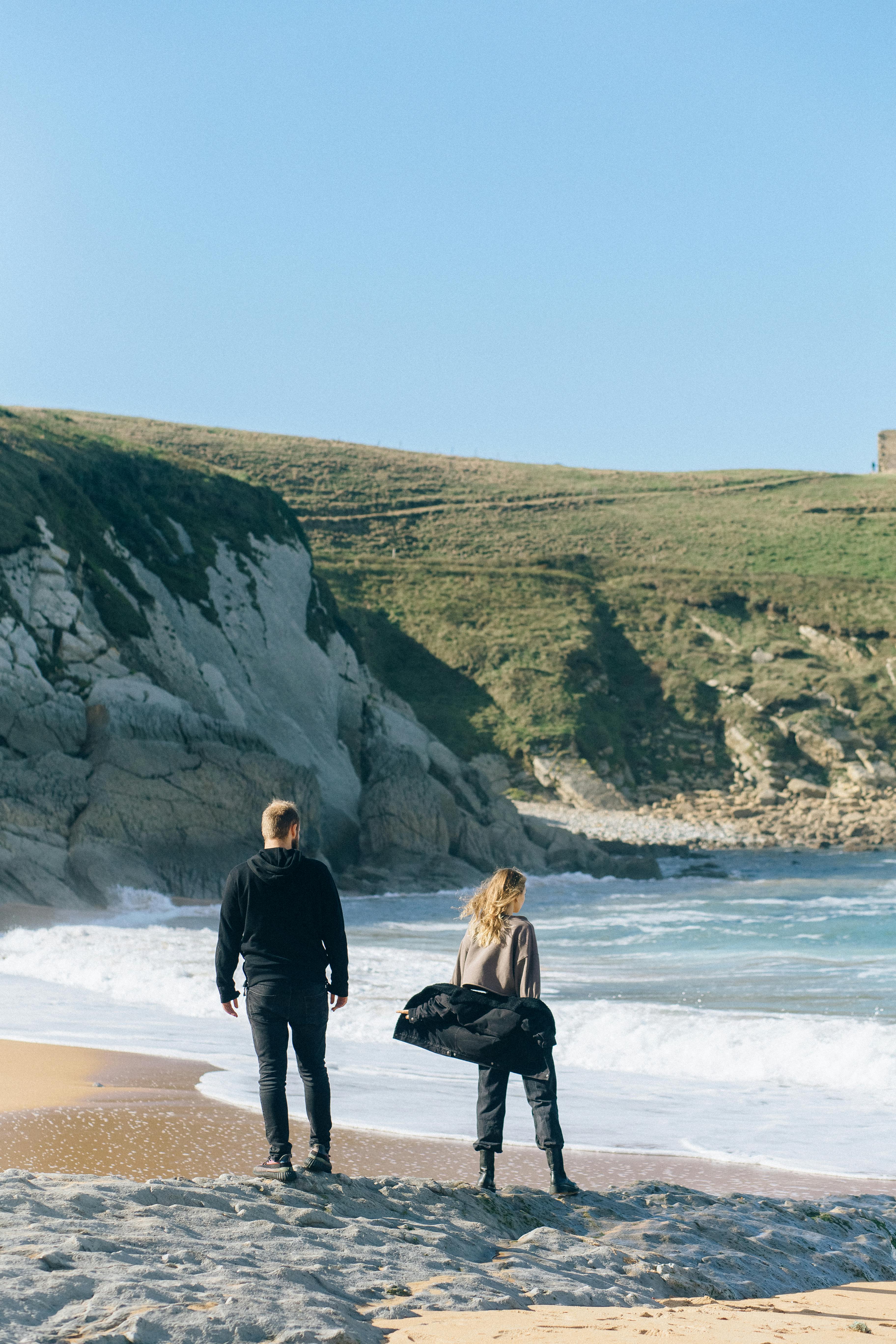 back view of a couple standing on beach