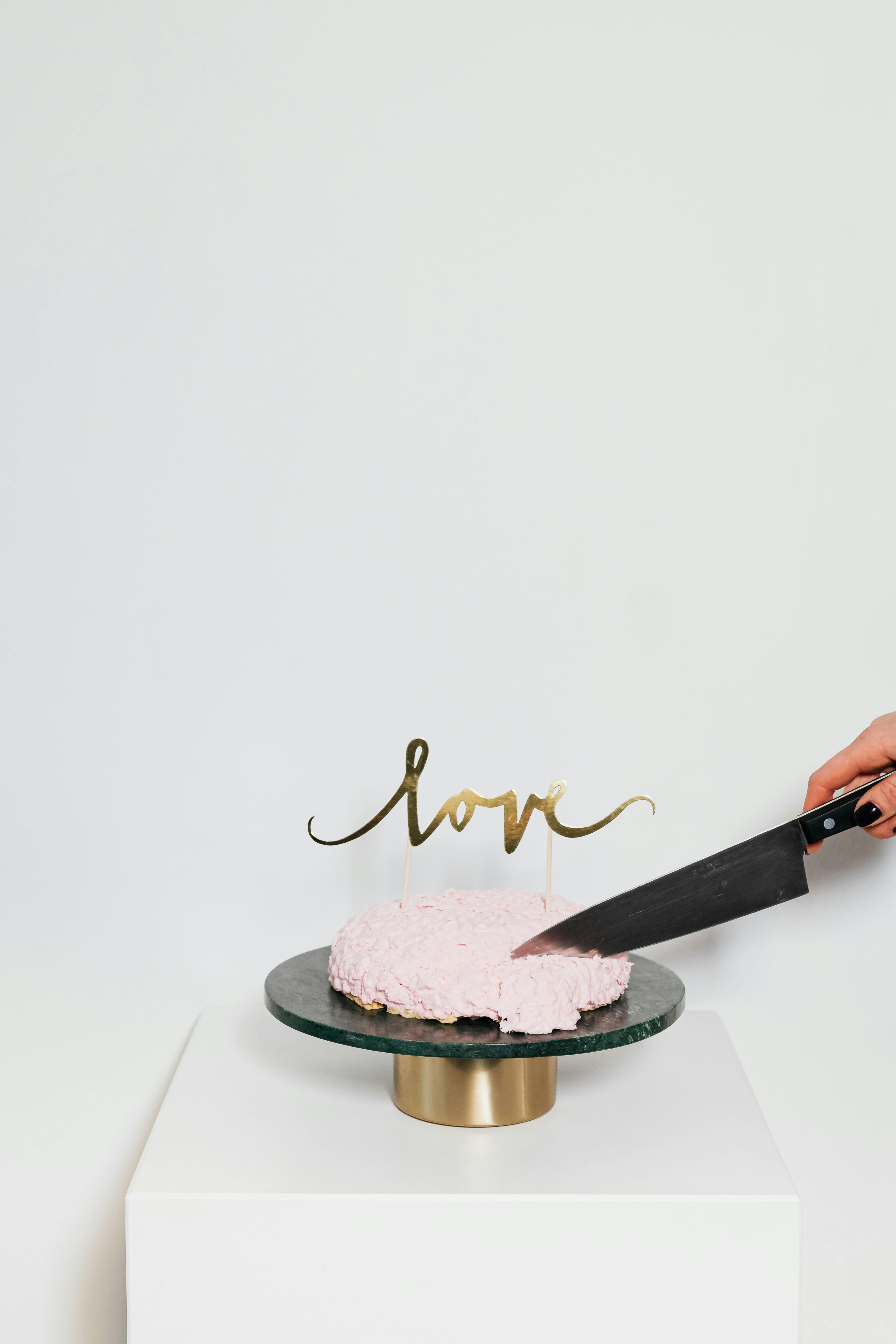 一张极简主义的图片，蛋糕被切片，顶部装饰着“爱”字