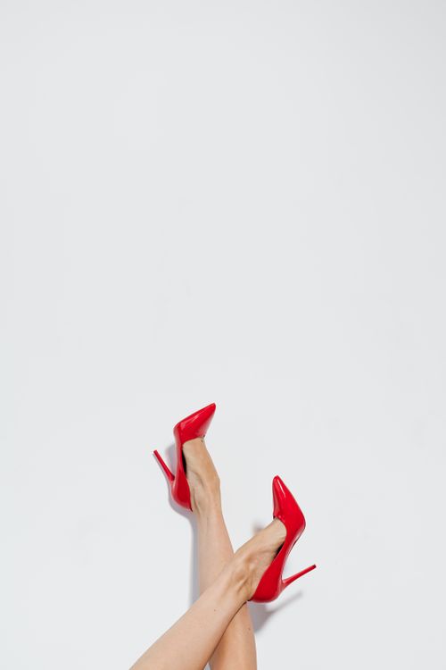 Free Stylish red high heels worn by a woman against a white background, featuring copy space. Stock Photo