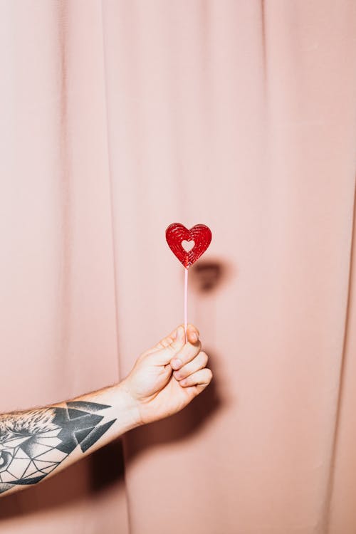 Free Person Holding Red Heart Lollipop Stock Photo