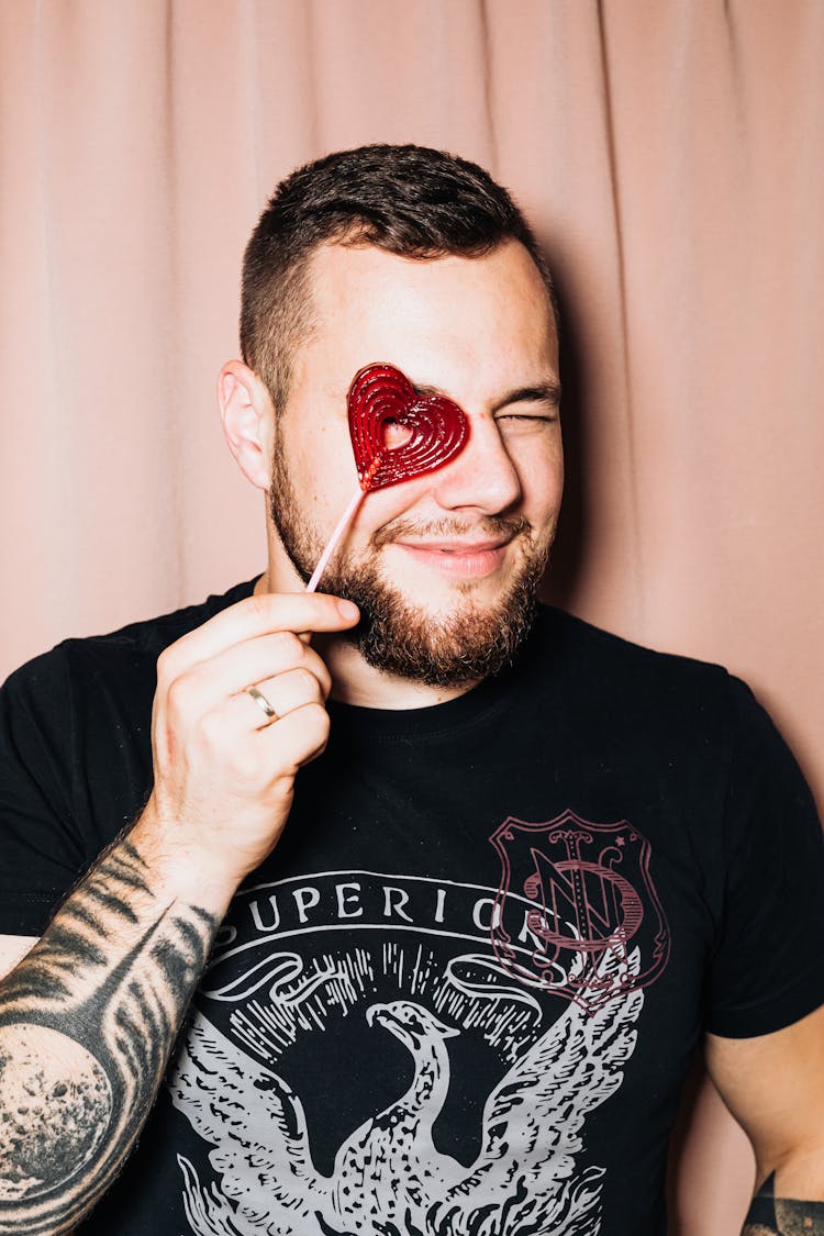 Man Holding Red Heart Lollipop