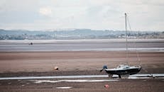 退潮时，英国德文郡埃克塞特的一艘帆船停在沙滩上