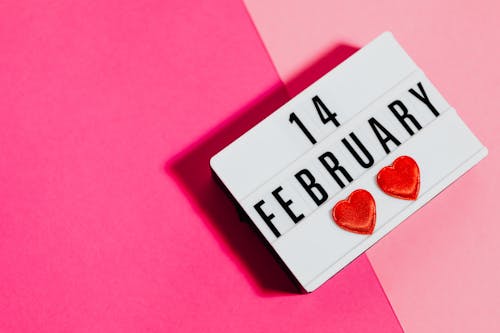 A Light Up Message Board with 14 February Written on It on a Pink Background 