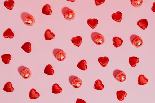 Free Hearts and Candy Against Pink Background Stock Photo