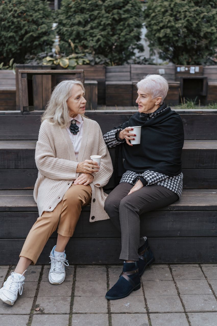Dos amigas mayores conversando en un banco
