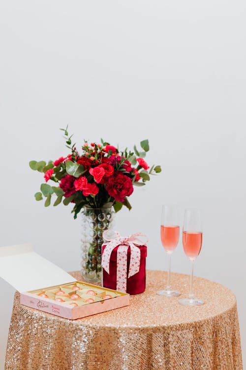Free Flowers, Chocolates, a Gift and Glasses of Champagne on a Table Stock Photo