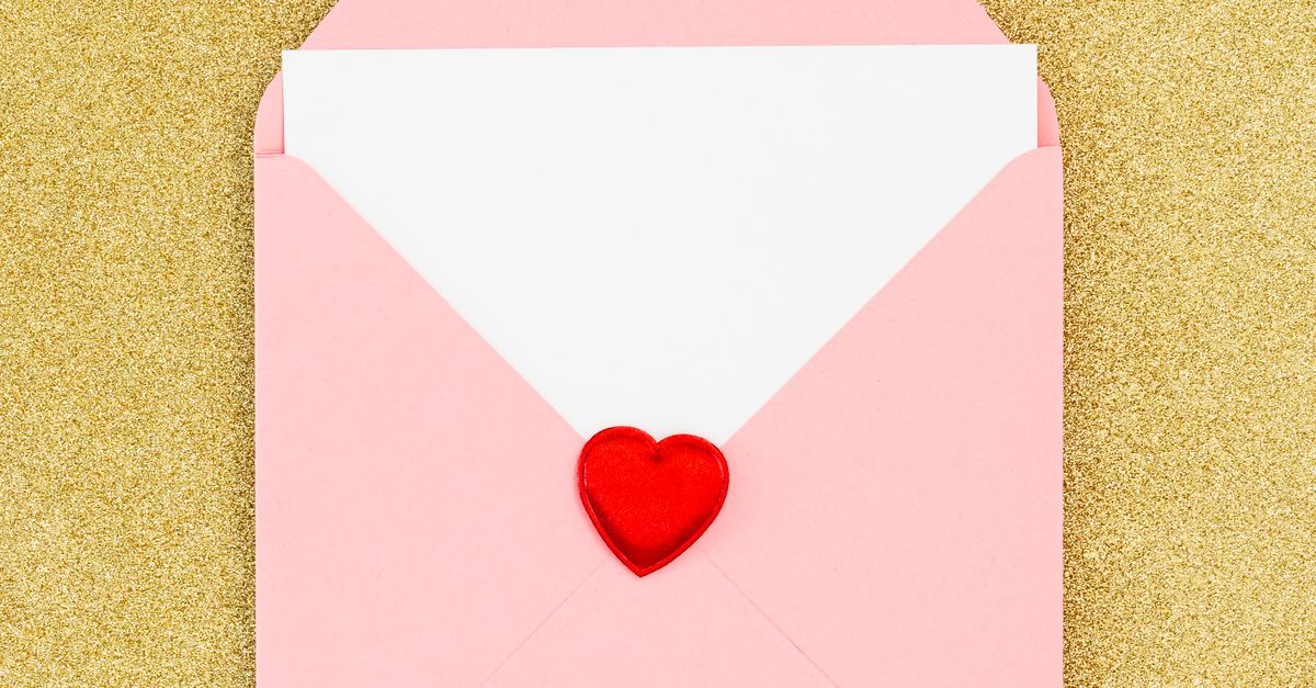 Rüyada Aşk Mektubu Almanın Derin Anlamları - Rüya Tabiri ve Anlamı - A pink envelope with a red heart sticker on a gold glitter surface, symbolizing love and romance.