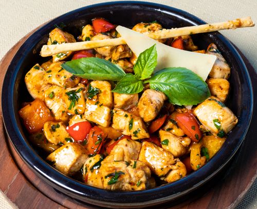Free A vibrant grilled chicken salad garnished with fresh basil leaves and served in a rustic bowl. Stock Photo