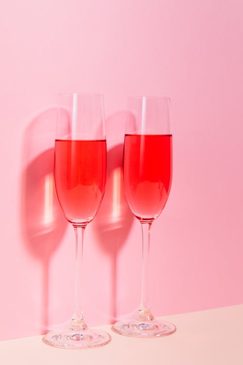 Free Two Glasses of Red Wine on Light Pink Background  Stock Photo