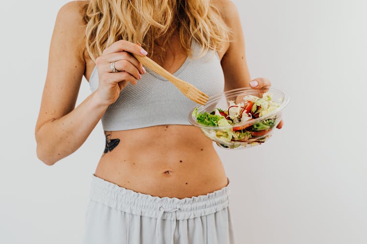 Toned Woman Eating Vegetable Salad