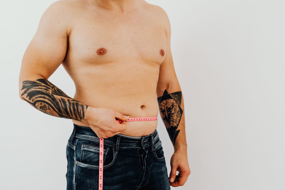Man measuring his waist with a tape measure