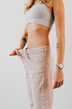 女性穿上超大裤子来减肥，以凸显转型效果