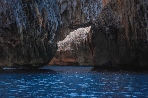 Free Picturesque blue sea with rippled surface with huge rough rocky formation on sunny day Stock Photo