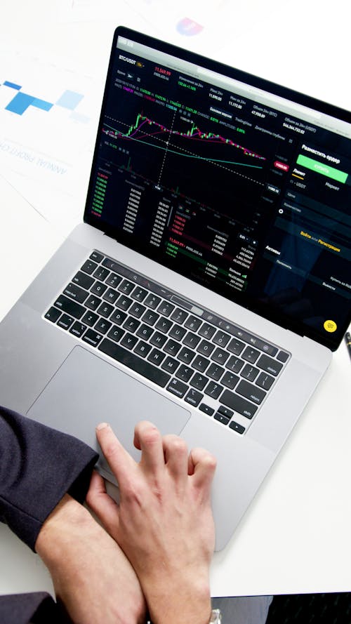 Person Using Macbook Pro on White Table