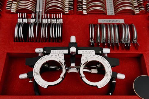 High angle collection of various trial lenses and frame placed in red holder in ophthalmology clinic