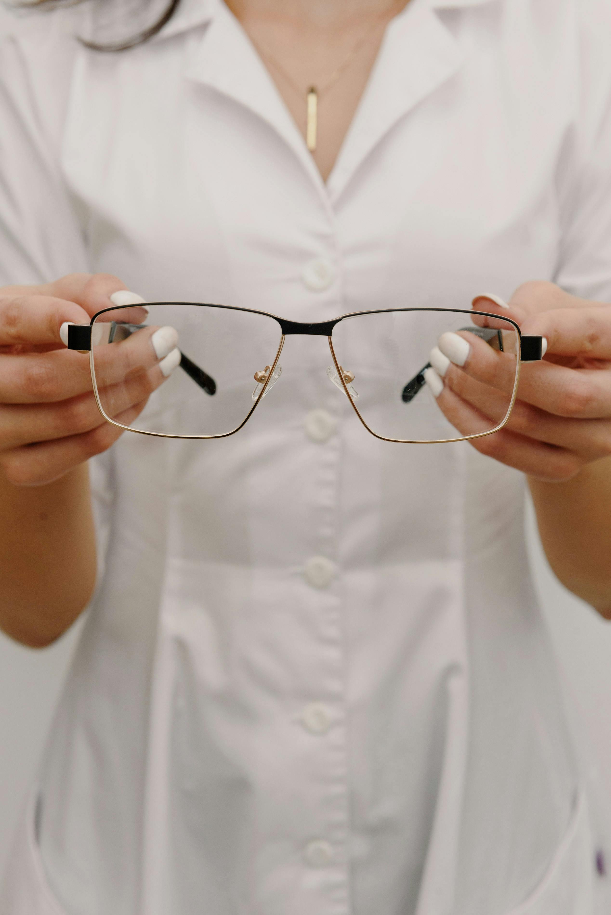 crop faceless female optometrist demonstrating eyeglasses