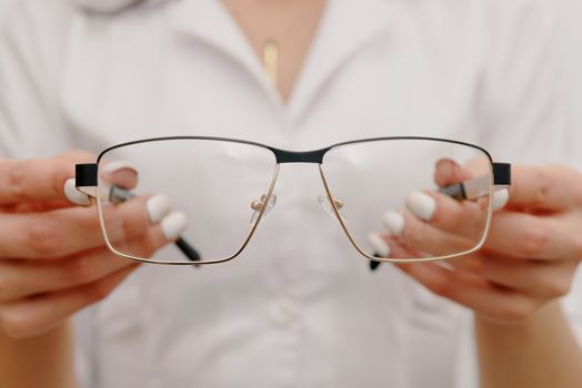 特写镜头中，验光师手持眼镜，说明其护理与精度