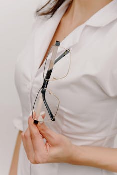 Closeup of an optometrist holding stylish eyeglasses, showcasing modern eyewear.