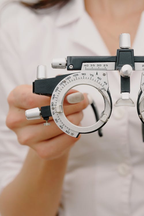 Free Crop unrecognizable female optometrist with trial frame in hands Stock Photo