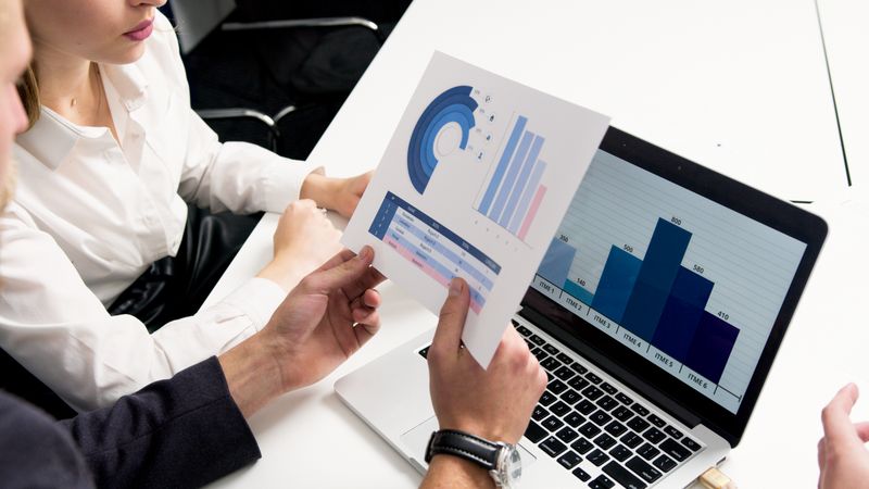 Professional handshake across a desk with documents, suggesting insurance consultation and client trust.
