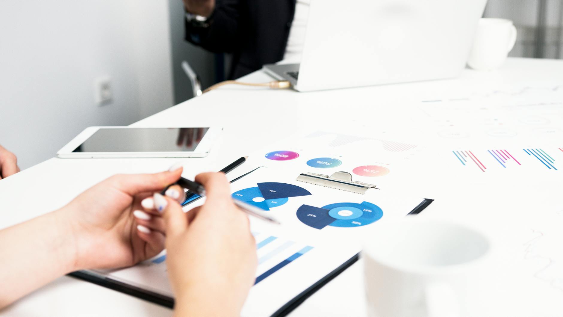 Team working on financial analysis with charts, data, and digital devices in an office setting.