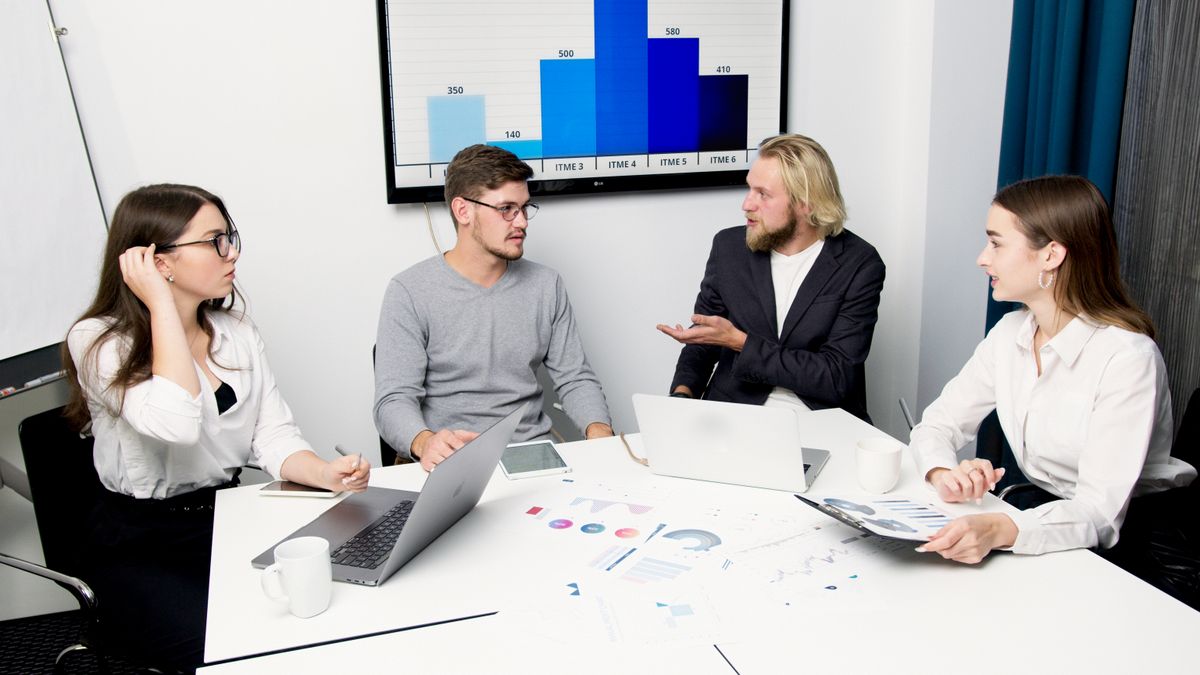Equipe analisando dados de vendas e comportamento de clientes em reunião