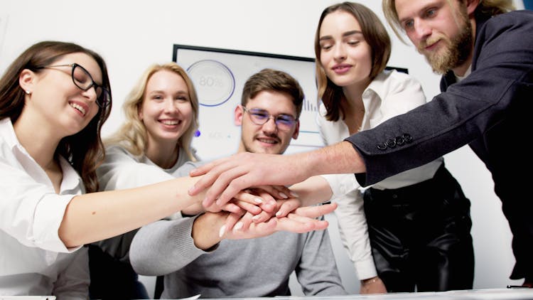 A Group Of People Huddle During A Meeting